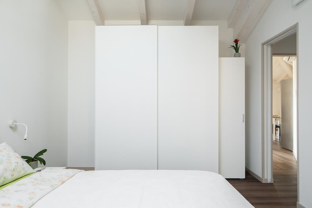 camera da letto con armadio bianco e letto